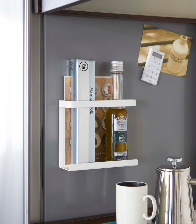 White Magnetic Wrap Holder holding oil and cooking paper by Yamazaki home.