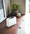 White Face Mask Dispenser holding pen and lipstick on cover tray by Yamazaki Home.