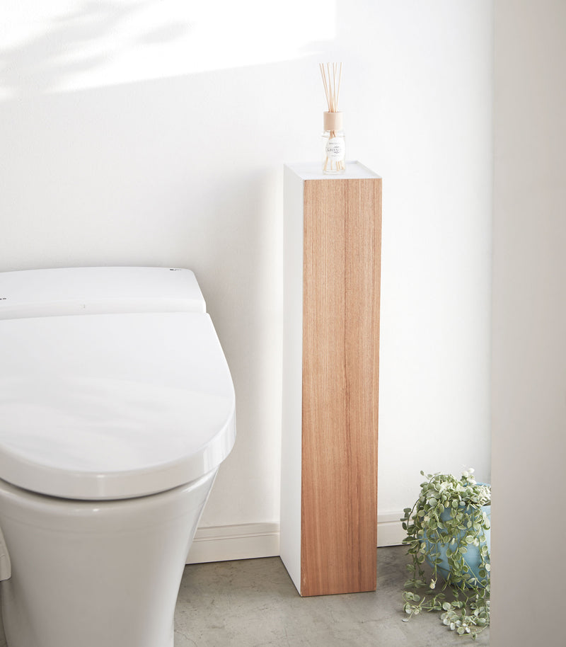 Front view of Toilet Paper Stocker displaying fragrance bottle in bathroom by Yamazaki Home.