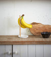 White Expandable Countertop Organizer on kitchen counter holding kitchen gadgets by Yamazaki Home.