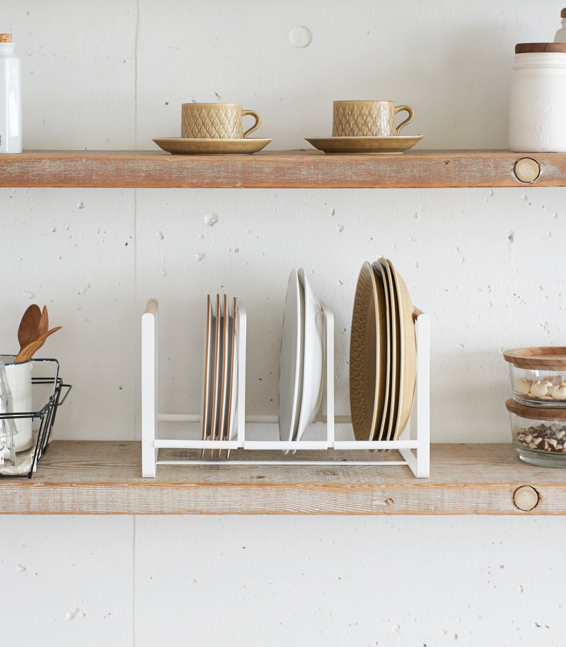 Front view of Wood-Accented Dish Storage Rack displaying plates on kitchen shelf by Yamazaki Home.