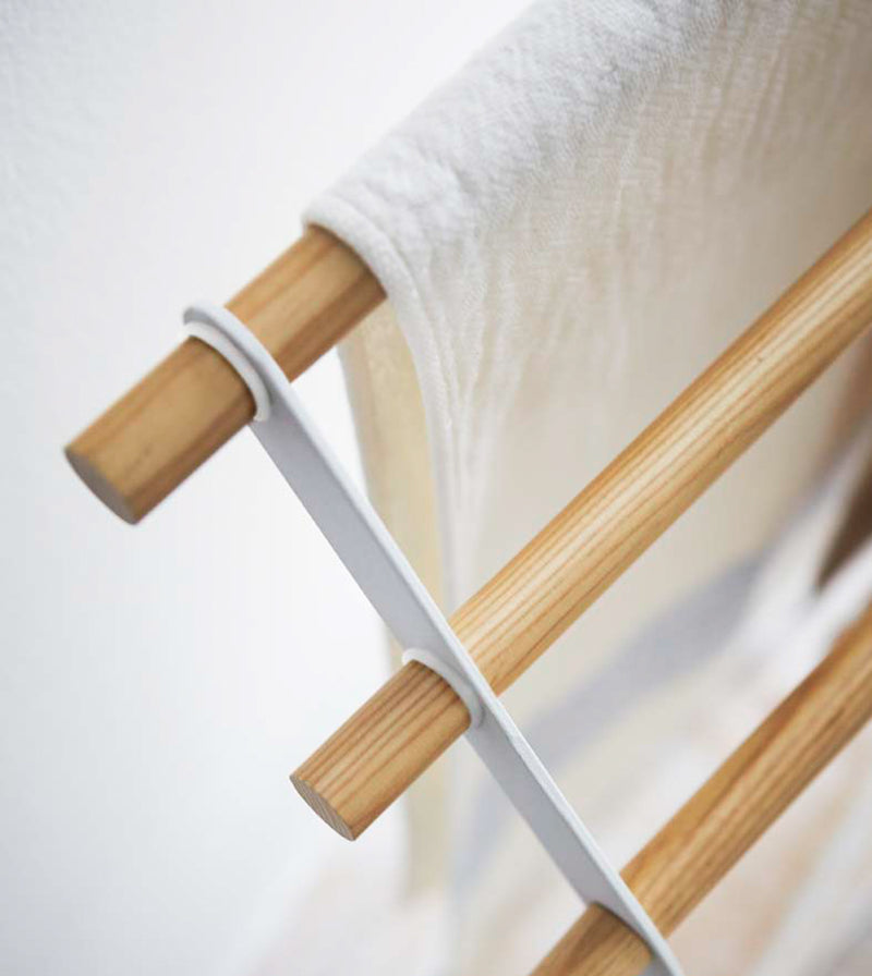 Aerial close up corner view of Bath Towel Rack holding towel on white background by Yamazaki Home.