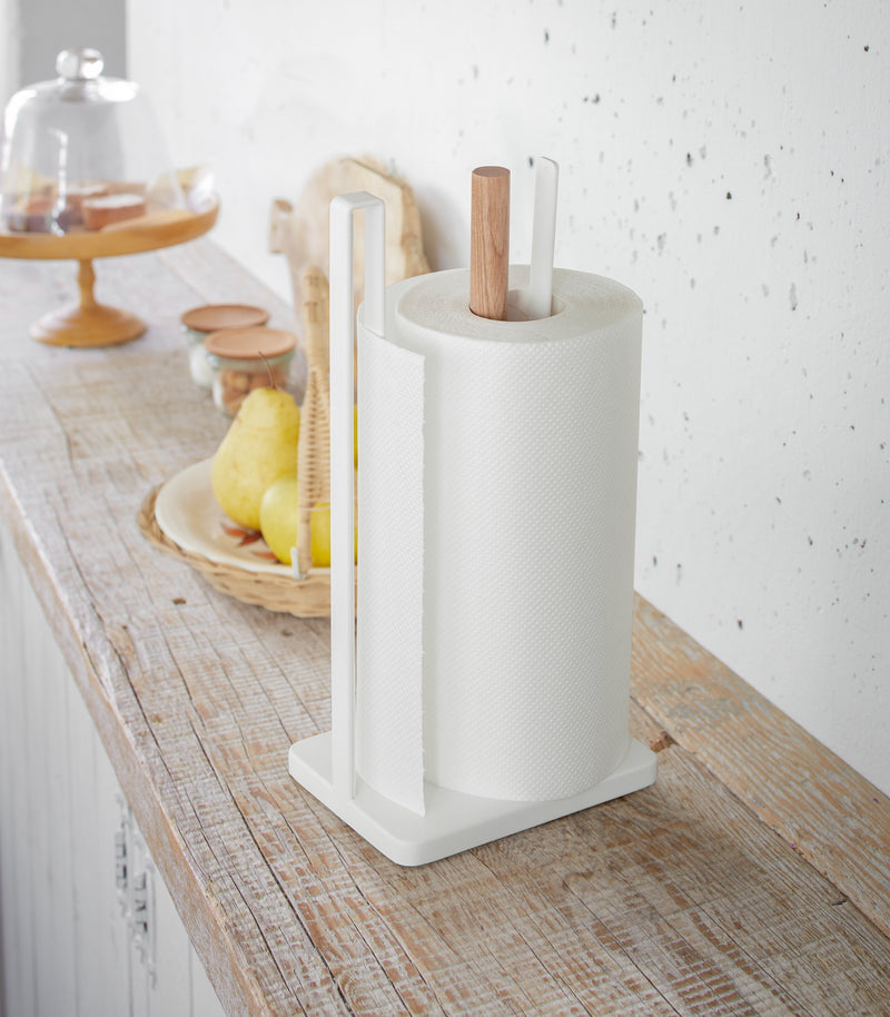 Paper Towel Holder holding paper towel on shelf in kitchen by Yamazaki Home.