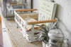Side view of white Storage Basket holding book and cloth napkins on shelf by Yamazaki Home.