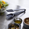 Side view of black Floating Slotted Tongs on kitchen countertop by Yamazaki Home.