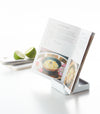 White Lid & Ladle Stand holding cookbook on white background by Yamazaki Home.